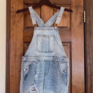Blue ripped jean overalls